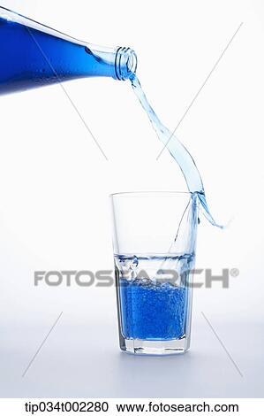 Stock Image - glass being filled with blue water. Fotosearch