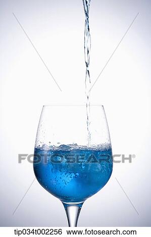 Stock Photograph - glass being filled with blue water. Fotosearch