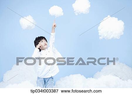 Stock Photo - little boy looks of angel on the clouds. Fotosearch