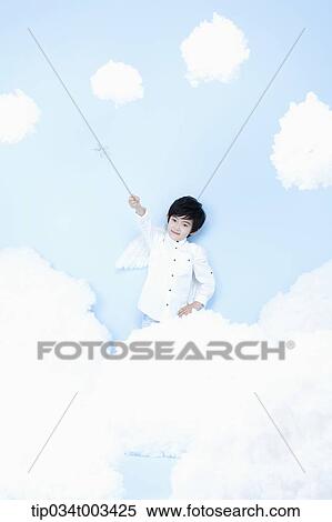 Stock Photography - little boy looks of angel on the clouds. Fotosearch