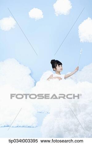 Stock Photography - little girl looks of angel on the clouds. Fotosearch