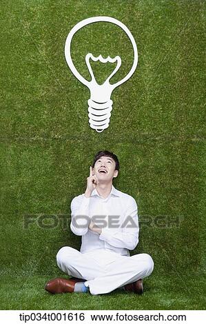 Stock Photograph - man coming up with idea under the bulb. Fotosearch