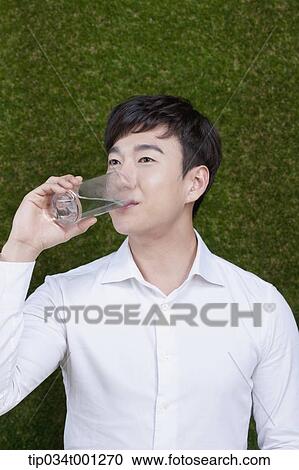 Stock Image - man drinking a glass of water. Fotosearch