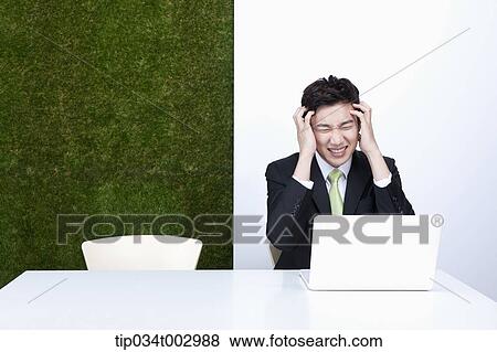 Stock Photo - man grabbing his head. Fotosearch