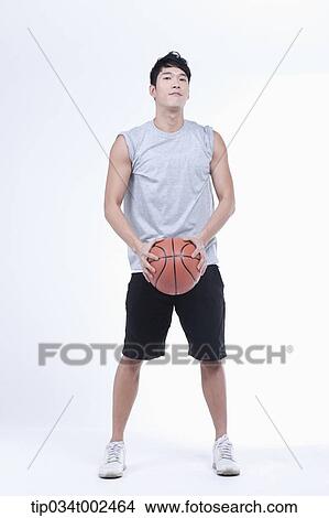 Picture - man holding a basketball. Fotosearch