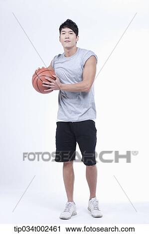Stock Image - man holding a basketball. Fotosearch