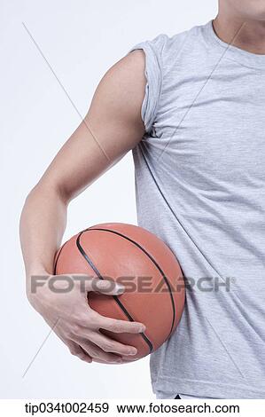 Stock Photo - man holding a basketball. Fotosearch