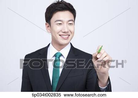 Stock Photography - man holding a green pen. Fotosearch