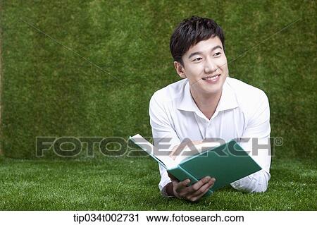 man lying face and reading a book View Large Photo Image Stock Image - man lying face and reading a book. Fotosearch