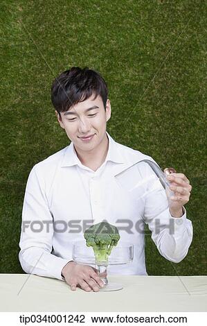 Stock Image - man opening the broccoli box. Fotosearch