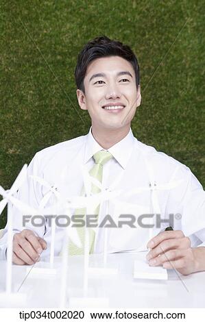 Stock Image - man playing with pinwheels on the table. Fotosearch