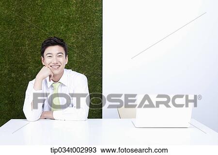 Stock Image - man resting his chin on his hand with smile. Fotosearch