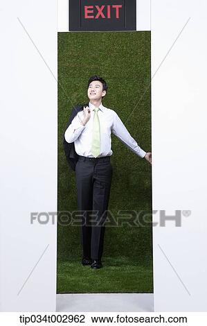 Stock Image - man standing inside the exit with his arm open. Fotosearch