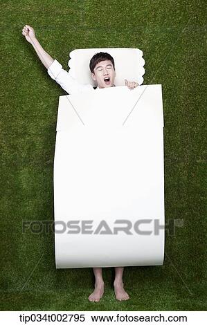 Stock Photography - man stretching himself in the paper bedding. Fotosearch
