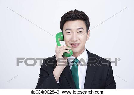 Stock Photo - man talking through green phone. Fotosearch