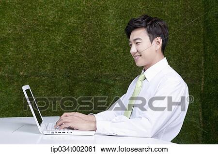 Stock Image - man using computer on the table. Fotosearch