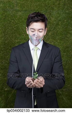 Stock Image - man wearing respirator and holding buds in his hands. Fotosearch