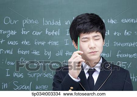schoolboy holding a pen and thinking of an idea View Large Photo Image Picture - schoolboy holding a pen and thinking of an idea . Fotosearch
