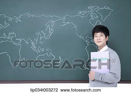 schoolboy standing in front of the blackboard with a book in his hand View Large Photo Image Stock Image - schoolboy standing in front of the blackboard with a book in his hand. Fotosearch