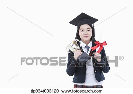 Stock Image - schoolgirl holding graduation certification and trophy . Fotosearch
