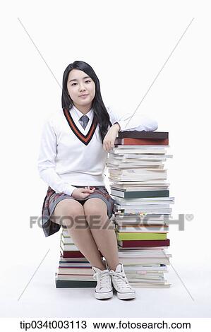 schoolgirl sitting on a stack of books View Large Photo Image Stock Image - schoolgirl sitting on a stack of books . Fotosearch