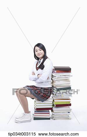 schoolgirl sitting on a stack of books View Large Photo Image Stock Photography - schoolgirl sitting on a stack of books . Fotosearch