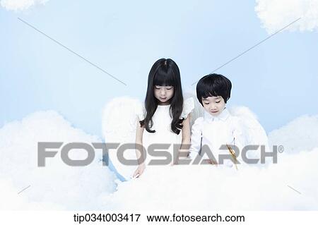 Stock Photo - two kids with looks of angels on the clouds. Fotosearch