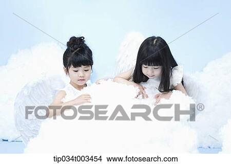 Picture - two little girls with looks of angels on the clouds. Fotosearch