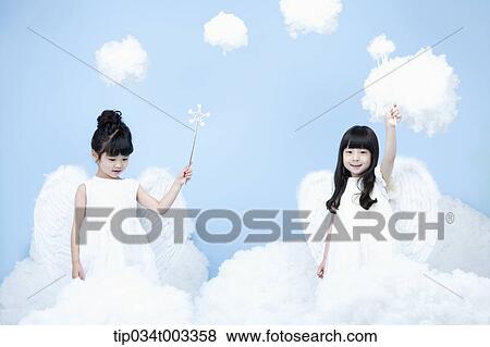 Stock Photo - two little girls with looks of angels on the clouds. Fotosearch
