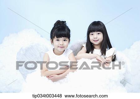 Stock Photo - two little girls with looks of angels on the clouds. Fotosearch