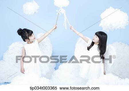 Stock Photography - two little girls with looks of angels on the clouds. Fotosearch
