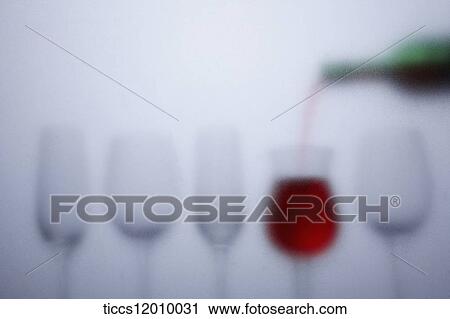 Stock Image - unclear picture of a wine pouring a redwine. Fotosearch