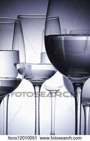 Stock Image - Wine glasses filled with water overlapping one another. Fotosearch
