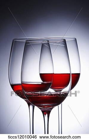 Stock Photograph - Wine glasses layered in each other filled with red wine. Fotosearch