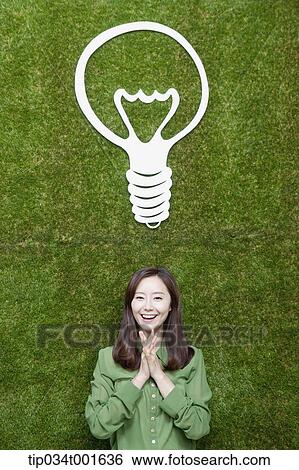 Stock Photograph - woman coming up with idea together under the bulb. Fotosearch