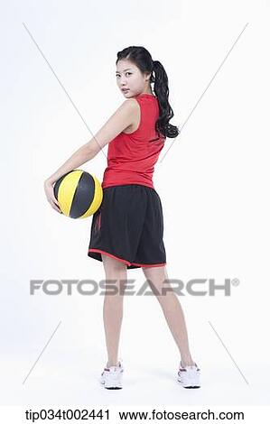 Stock Image - woman holding a beach ball . Fotosearch