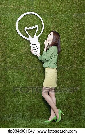 Stock Photo - woman holding a bulb on her hand. Fotosearch