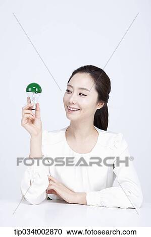 woman holding a green bulb View Large Photo Image Stock Image - woman holding a green bulb. Fotosearch