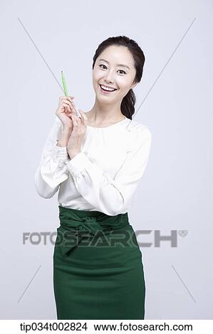 Picture - woman holding a green pen. Fotosearch