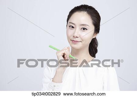 Stock Photo - woman holding a green pen. Fotosearch