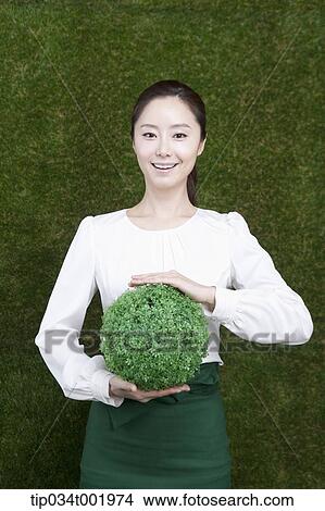 woman holding a sphere covered with grass View Large Photo Image Picture - woman holding a sphere covered with grass. Fotosearch
