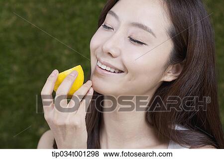 Stock Photo - woman holding lemon on her hands . Fotosearch