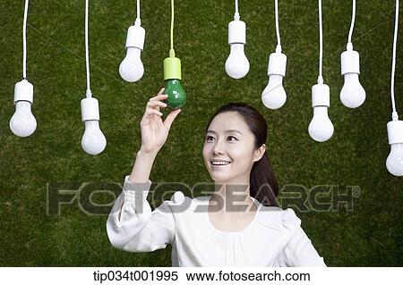 woman holding one the bulbs hanging on the ceiling View Large Photo Image Stock Photography - woman holding one the bulbs hanging on the ceiling. Fotosearch