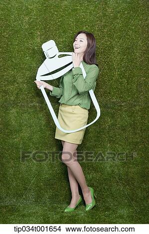 Picture - woman holding the bottle with her hands. Fotosearch