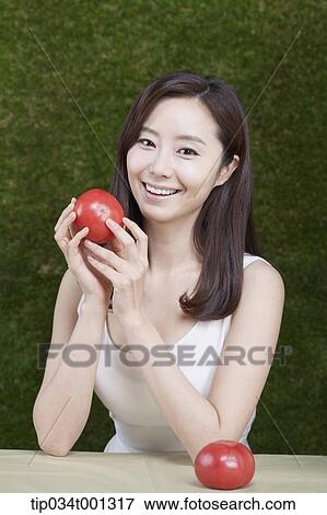 Stock Photo - woman holding tomatoes on her hands . Fotosearch