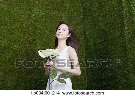 Picture - woman holding white flower. Fotosearch