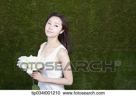 Stock Image - woman holding white flower. Fotosearch