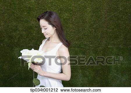 Stock Image - woman holding white flower. Fotosearch
