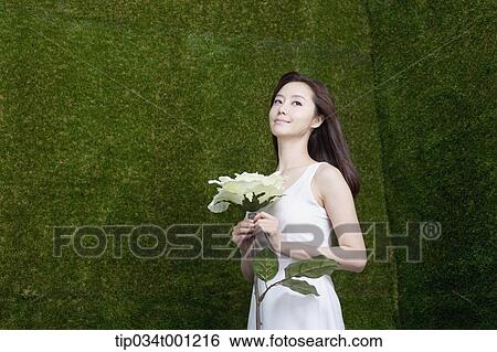 Stock Photograph - woman holding white flower. Fotosearch