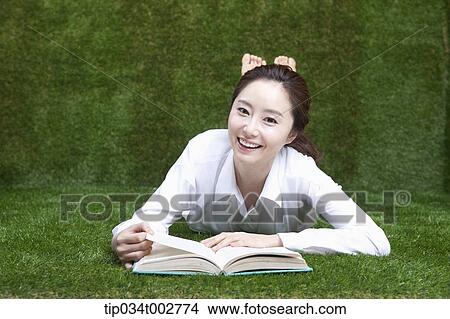 woman lying face and reading a book View Large Photo Image Picture - woman lying face and reading a book. Fotosearch